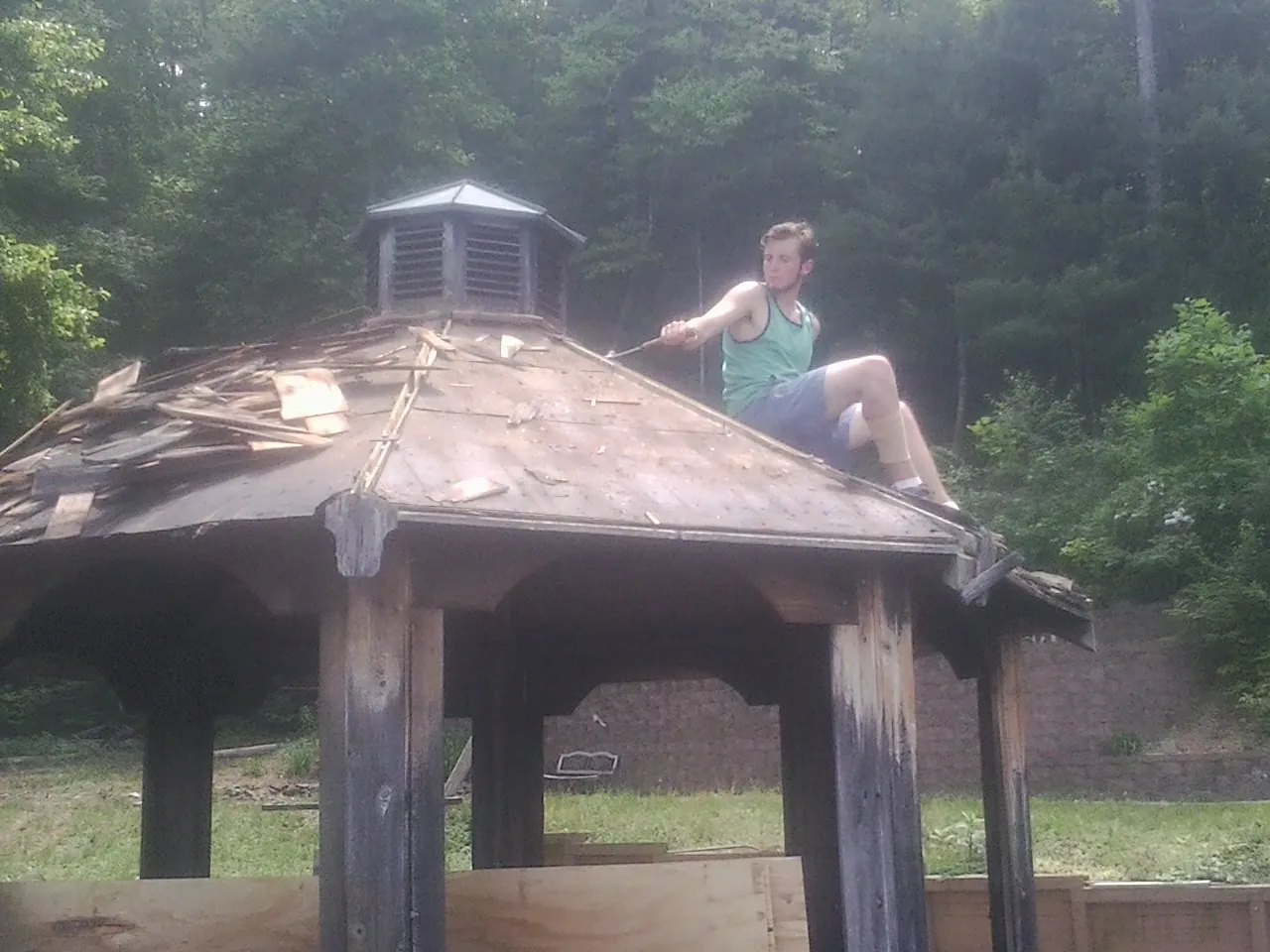Tearing the old roof off a wooden gazebo before new shakes in Middleburg
