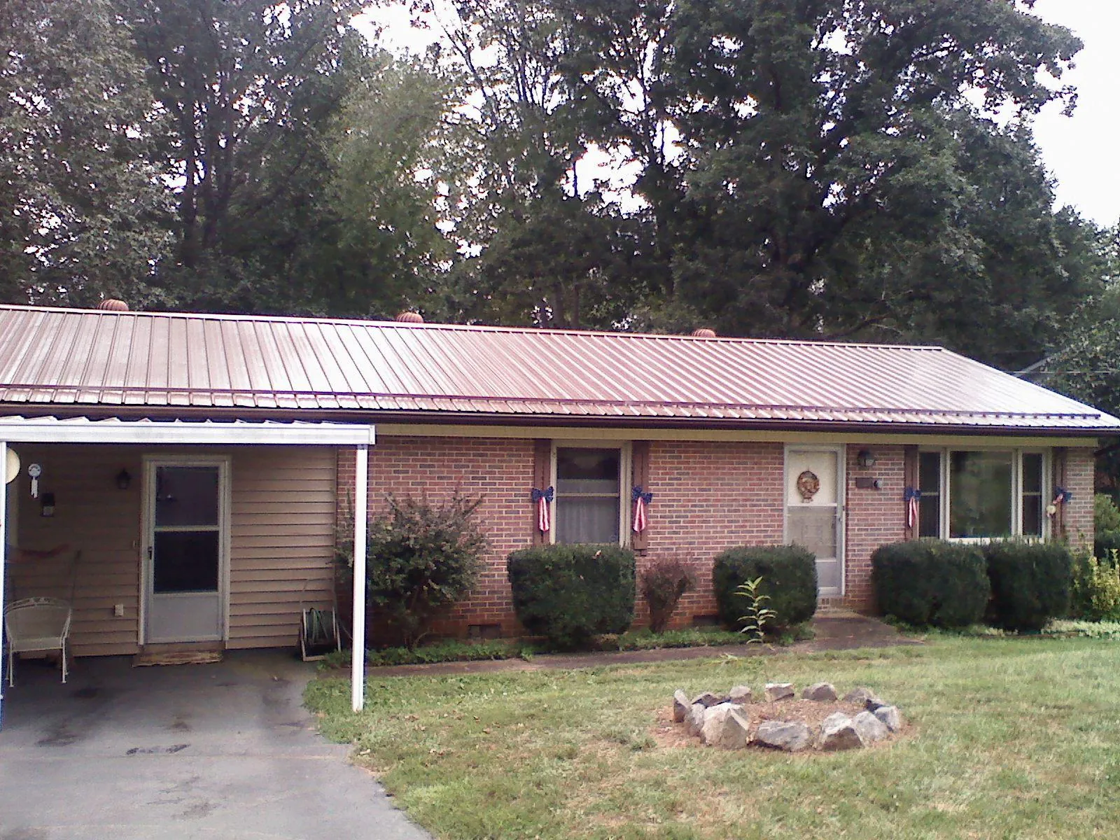 Bronze metal roof and carport on a brick ranch home — Roof Repair work by our crew in Middleburg
